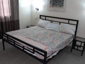 a bedroom with a bed with a quilt on it at Logement familial et groupe in Sali Nianiaral