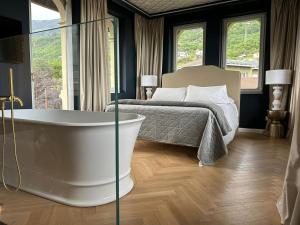 Villa Sardino في Settimo Vittone: غرفة نوم مع حوض استحمام بجانب سرير