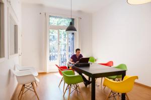 un uomo seduto a un tavolo con un portatile di Ramblas Apartments a Barcellona