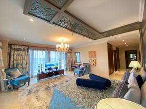 uma sala de estar com um sofá azul e uma televisão em Grand Hotel Djibloho em Djibloho
