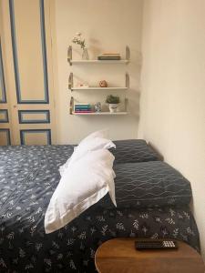 - un lit avec 2 oreillers et une télécommande dans l'établissement Un séjour à Tours centre place des Halles, à Tours