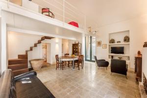 a living room with a table and a dining room at Villetta con giardino nel centro storico in Procida