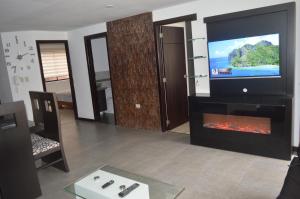 sala de estar con TV y chimenea en Departamento de lujo Condominio ADMIRA, en Cuenca