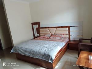een slaapkamer met een bed met een houten hoofdeinde bij Galaxy Inn Homestay in Banikhet