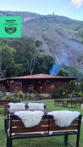 un grupo de bancos con almohadas blancas frente a un edificio en Kastel Pedra Bonita, en Petrópolis