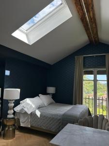 a bedroom with a bed and a skylight at Villa Sardino in Settimo Vittone