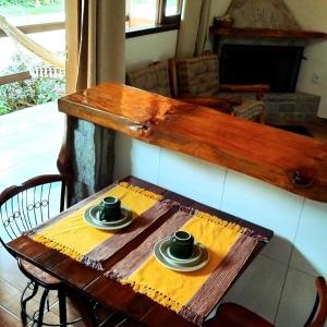 una mesa de madera con dos tazas encima en Recanto KAIRÓS, en Visconde De Maua
