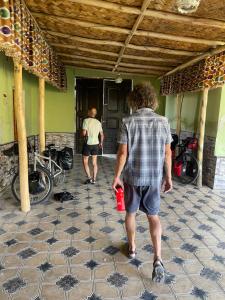 deux hommes marchant dans un bâtiment avec une coupe rouge dans l'établissement Sohil boyi, à Ferghana