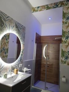 bagno con doccia, lavandino e specchio di Suite al Borgo ad Aversa