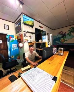 サンホセにあるコスタリカ バックパッカーズの職場の机に座る男