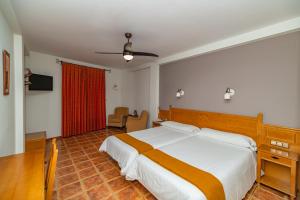 a bedroom with a large bed and a red curtain at La Fragua II in Trevélez