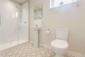 a bathroom with a toilet and a sink and a shower at Duet Lodge in Kingham +2 photos