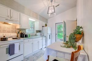 una cocina con armarios blancos y una mesa con una planta. en Roanoke Mountain Home 4 Mi to Blue Ridge Parkway! en Roanoke