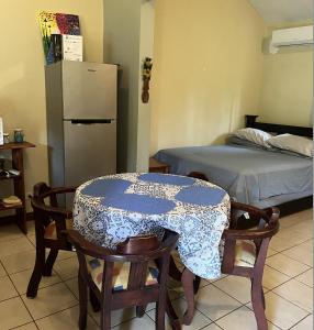 Habitación con mesa, sillas y cama en Tucan Studio Ocotal en Coco