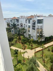 a view of a courtyard with palm trees and buildings at Chez khadija in Asilah