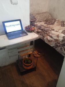 a laptop computer sitting on a desk next to a bed at avtostop.bicykle.tent in Meghri