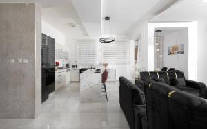 ein Wohnzimmer mit schwarzen Stühlen und eine Küche in der Unterkunft וילה Royal in Eilat