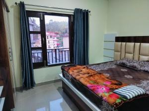een slaapkamer met een bed en een groot raam bij Galaxy Inn Homestay in Banikhet