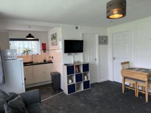 a living room with a table and a kitchen at 21 M&T Chalets ,2 bed chalet Florida holiday park , Hemsby in Hemsby
