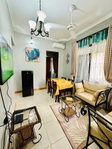 a living room with a couch and a tv and a table at Queen Elizabeth Apartment in Dar es Salaam