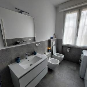 a bathroom with a sink and a toilet and a mirror at La Pineta, 26 - 5 in Casarza Ligure