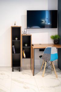 a desk with a tv on a wall with a chair at Δ17 Suites & Apartments in Larisa