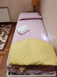 a bed with a yellow blanket on it in a room at Ameno house in Casale SantʼAntonio