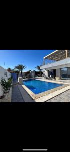 a large house with a swimming pool in front of it at Dar Zina in Al Maqārisah