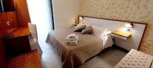 a bedroom with a bed with two towels on it at Hotel Brotas in Rimini
