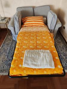 a bed with an orange blanket on top of it at Ameno house in Casale SantʼAntonio