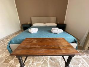 a bedroom with a bed and a wooden table at Le Gorgoni b&b in Syracuse