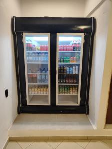 a refrigerator with two doors full of drinks at VILLA BILAC 01 - Studio próximo à Vila Germânica in Blumenau