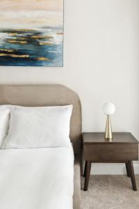 Un dormitorio con una cama y una mesa con una lámpara. en Kasa Village District Raleigh, en Raleigh