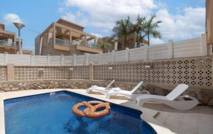 una piscina con 2 sillas y un pretzel en el agua en וילה Royal, en Eilat