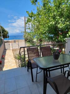 een patio met een tafel en stoelen en de oceaan bij Akrotiri Luxury Suites in Trápeza