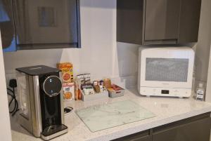 a kitchen counter with a coffee maker and a microwave at Room on the River in Cruden Bay