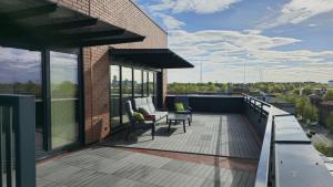 un toit-terrasse avec des chaises et des tables dans un bâtiment dans l'établissement Artisa Riia Str 22 Luxury Penthouse Apartment - 8th fl, à Tartu