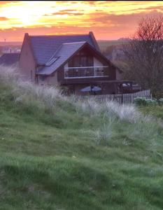 a house sitting on top of a grassy hill at Room on the River in Cruden Bay
