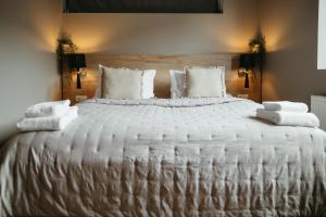 - un grand lit blanc avec des couvertures et des oreillers blancs dans l'établissement Vík Apartments, à Vík