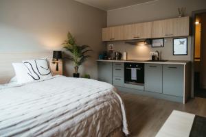a bedroom with a white bed and a kitchen at Vík Apartments in Vík