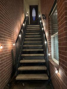 a staircase with lights and a brick wall at The Hanger in Houston