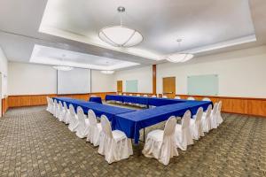 uma sala de conferências com uma mesa azul e cadeiras brancas em Fiesta Inn Colima em Colima