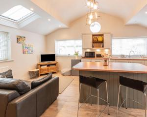 cocina y sala de estar con sofá y mesa en Quiet Self contained Cottage near Delamere Forest en Cuddington