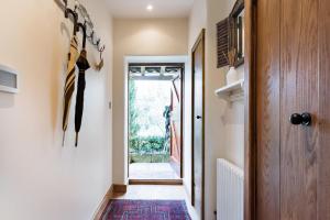 een hal die leidt naar een deur met een tapijt bij Romantic Little House near Bath in Rode