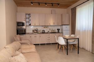 安布羅勞里的住宿－Forest Side Gogolati，带沙发和桌子的客厅以及厨房。