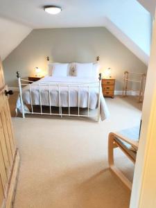 a bedroom with a white bed in a attic at Squirrels' Drey in Innerleithen
