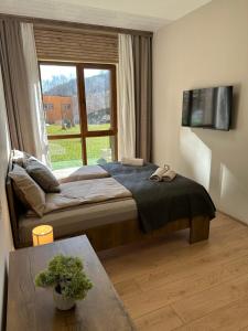 sypialnia z łóżkiem i oknem w obiekcie Apart-Hotel Crown Bansko 2 w mieście Bansko