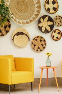 a living room with a yellow couch and plates on the wall at Ella Suites Hotel in Antalya