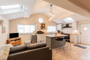 a living room with a couch and a kitchen at Quiet Self contained Cottage near Delamere Forest in Cuddington