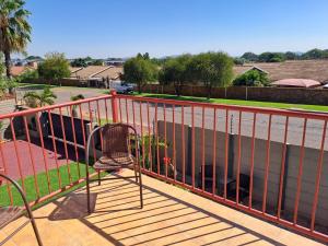 einen Stuhl auf einem Geländer auf einem Balkon in der Unterkunft Christa's Place 899 in Pretoria